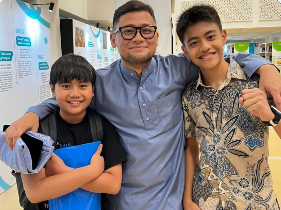 Two students with a teacher at Al-Izhar Pondok Labu